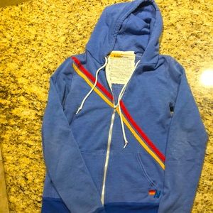 Lt blue red /yellow striping. Distressed super soft. SizeLarge more like medium.